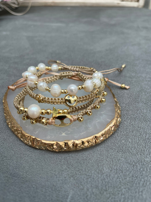 Gold braided bracelet with single white freshwater pearl